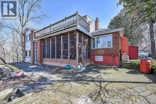 Rear view of house with a sunroom, brick siding, and a chimney - 9 Daleview Court, Hamilton, ON - Outdoor