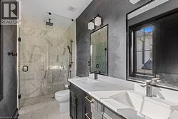 Full bathroom featuring toilet, marble finish floor, a shower stall, and a sink - 