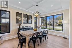 Dining room with light wood-style flooring, recessed lighting, coffered ceiling, baseboards, and a chandelier - 