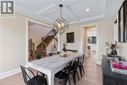Dining space featuring an inviting chandelier, light wood-style flooring, beamed ceiling, and stairs - 308 Appleby Line, Burlington, ON - Indoor Photo Showing Dining Room