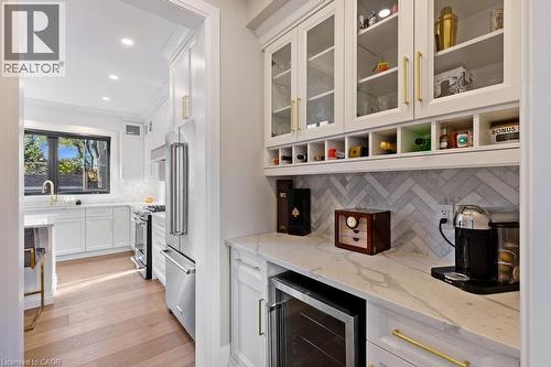 Bar with wine cooler, light wood-style flooring, high end appliances, crown molding, and backsplash - 308 Appleby Line, Burlington, ON - Indoor Photo Showing Kitchen