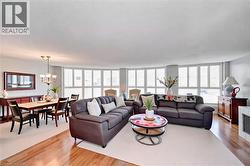 Living area featuring a chandelier, plenty of natural light, and light wood-style floors - 