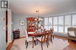 Dining space featuring a chandelier, light wood-type flooring, baseboard heating, and a textured ceiling - 