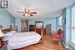 Bedroom featuring wood finished floors, a textured ceiling, and a ceiling fan - 