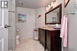 Full bathroom featuring vanity, baseboards, toilet, marble finish flooring, and a tile shower - 