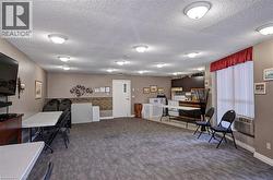 Office space with dark carpet, a textured ceiling, and baseboards - 