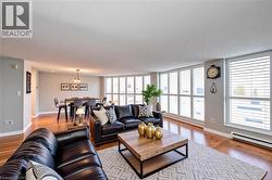 Living area featuring light wood finished floors, a baseboard heating unit, and baseboards - 