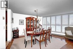 Dining area featuring a chandelier and wood finished floors - 