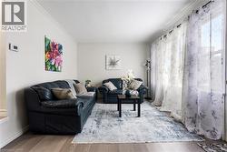 Living area featuring ornamental molding and wood finished floors - 