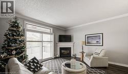 Living area with crown molding, a fireplace, a textured ceiling, and dark wood-type flooring - 