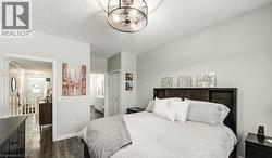 Bedroom featuring a textured ceiling, a closet, dark wood-style floors, and connected bathroom - 