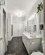 Full bathroom with curtained shower, dark marble finish floors, vanity, and a chandelier - 