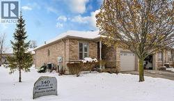 View of snow covered exterior with brick siding and an attached garage - 