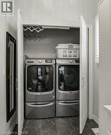Laundry room featuring separate washer and dryer and dark marble finish flooring - 