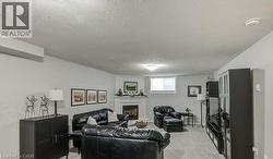 Living area featuring a textured ceiling, light carpet, and a fireplace - 