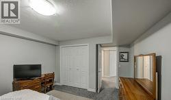 Carpeted bedroom with a textured ceiling and a closet - 