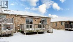 Snow covered property featuring a wooden deck and brick siding - 