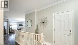 Corridor featuring ornamental molding, an upstairs landing, dark wood-type flooring, a textured ceiling, and a chandelier - 