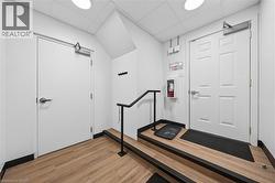 Entrance foyer with light wood-style flooring and a drop ceiling - 