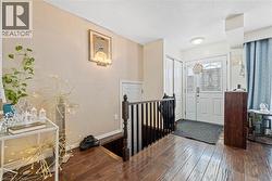 Entrance foyer with wood-type flooring, a textured ceiling, and a textured wall - 