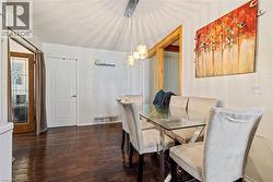 Dining room featuring dark wood finished floors and baseboards - 