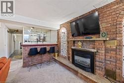 Living area with carpet floors, a textured ceiling, bar, and a large fireplace - 