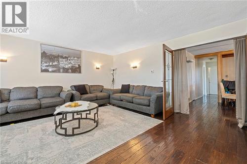 Living area with dark wood-style floors and a textured ceiling - 490 Queen Victoria Drive, Hamilton, ON - Indoor Photo Showing Living Room