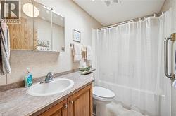 Bathroom featuring shower / bath combination with curtain and vanity - 