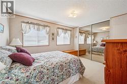 Bedroom with carpet, multiple windows, a textured ceiling, a closet, and crown molding - 