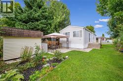 Rear view of house with a gazebo, a lawn, a patio, and an outdoor structure - 