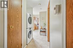 Laundry room featuring a textured ceiling and estacked washer and dryer - 