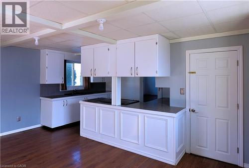 Kitchen with dark countertops, white cabinetry, a peninsula, dark wood finished floors, and black electric cooktop - 1448 Upper Ottawa Street, Hamilton, ON - Indoor