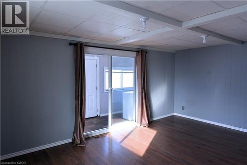 Spare room with dark wood-type flooring, wood walls, and beam ceiling - 1448 Upper Ottawa Street, Hamilton, ON - Indoor Photo Showing Other Room