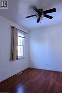 Spare room with dark wood-type flooring and a ceiling fan - 