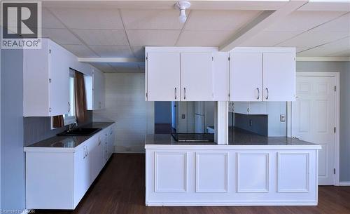 Kitchen featuring white cabinetry, a paneled ceiling, dark wood-style floors, freestanding refrigerator, and tile counters - 1448 Upper Ottawa Street, Hamilton, ON - Indoor Photo Showing Kitchen