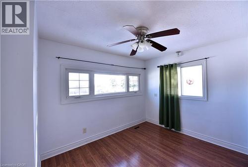 Unfurnished room with ceiling fan, a textured ceiling, healthy amount of natural light, and dark wood-style floors - 1448 Upper Ottawa Street, Hamilton, ON - Indoor Photo Showing Other Room