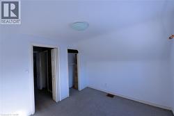 Additional living space featuring dark carpet and vaulted ceiling - 