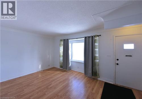 Foyer entrance featuring a textured ceiling and wood finished floors - 1448 Upper Ottawa Street, Hamilton, ON - Indoor Photo Showing Other Room