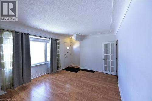 Empty room with a textured ceiling and wood finished floors - 1448 Upper Ottawa Street, Hamilton, ON - Indoor Photo Showing Other Room