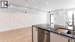 Kitchen with dishwasher, recessed lighting, white cabinets, and dark stone counters - 