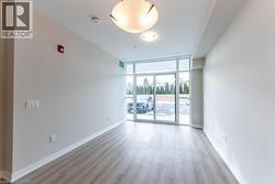 Unfurnished room featuring a wall of windows and light wood finished floors - 