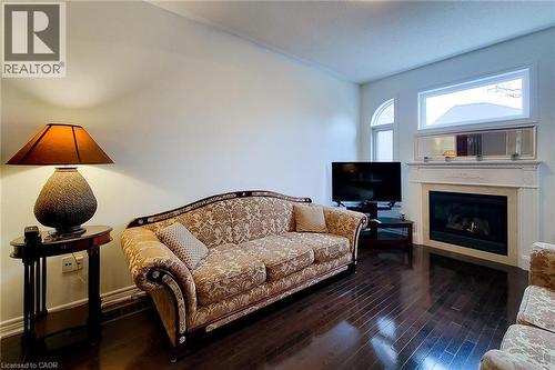 Living area with a glass covered fireplace and dark wood finished floors - 3362 Whilabout Terrace, Oakville, ON - Indoor With Fireplace