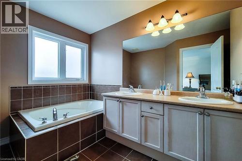 Bathroom with a garden tub, double vanity, and dark tile patterned floors - 3362 Whilabout Terrace, Oakville, ON - Indoor Photo Showing Bathroom