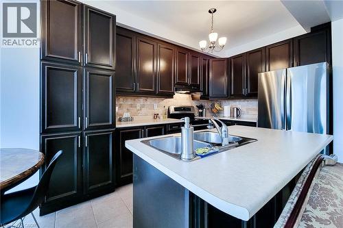 Kitchen featuring light countertops, an island with sink, appliances with stainless steel finishes, and decorative backsplash - 3362 Whilabout Terrace, Oakville, ON - Indoor Photo Showing Kitchen With Stainless Steel Kitchen With Double Sink With Upgraded Kitchen
