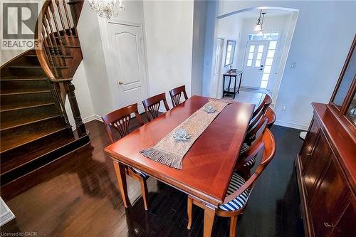 Dining space featuring arched walkways, a chandelier, stairs, french doors, and dark wood-type flooring - 3362 Whilabout Terrace, Oakville, ON - Indoor Photo Showing Dining Room