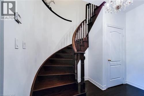 Staircase with a chandelier and wood finished floors - 3362 Whilabout Terrace, Oakville, ON - Indoor Photo Showing Other Room