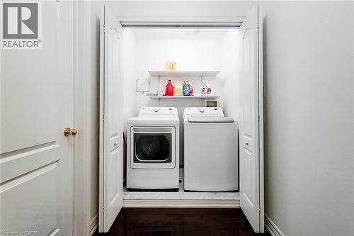 Laundry area featuring washer and clothes dryer and dark wood-style flooring - 3362 Whilabout Terrace, Oakville, ON - Indoor Photo Showing Laundry Room