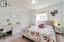 Bedroom featuring light carpet, a closet, and an office area - 