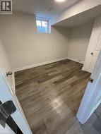 Basement with dark wood-type flooring and baseboards - 