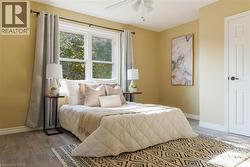 Bedroom with wood finished floors and a ceiling fan - 